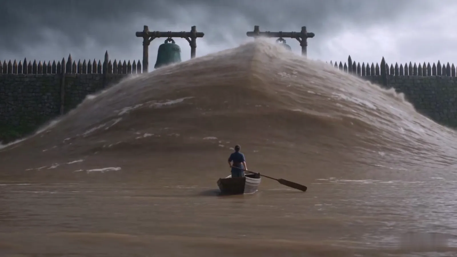A wall of floodwater rises under the bell posts of the Old Wall