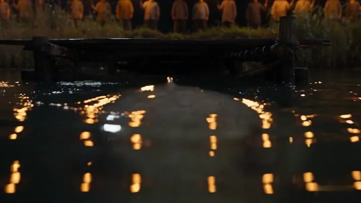 Candles float along the dark ferry landing